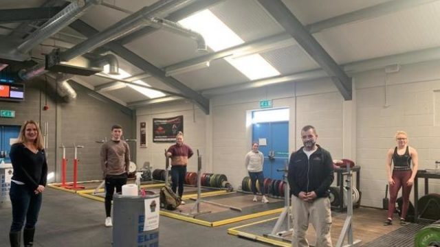 Coach and Lifters stand socially distanced for photo in HAWFC