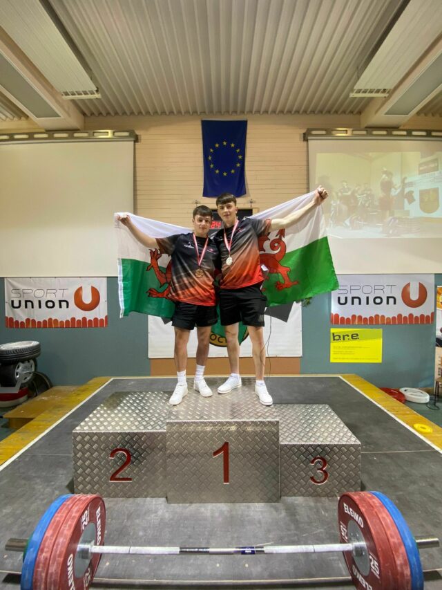 Ben Foggo and Cian Green on the podium with their Welsh flags at the Junior Battle 2022 min
